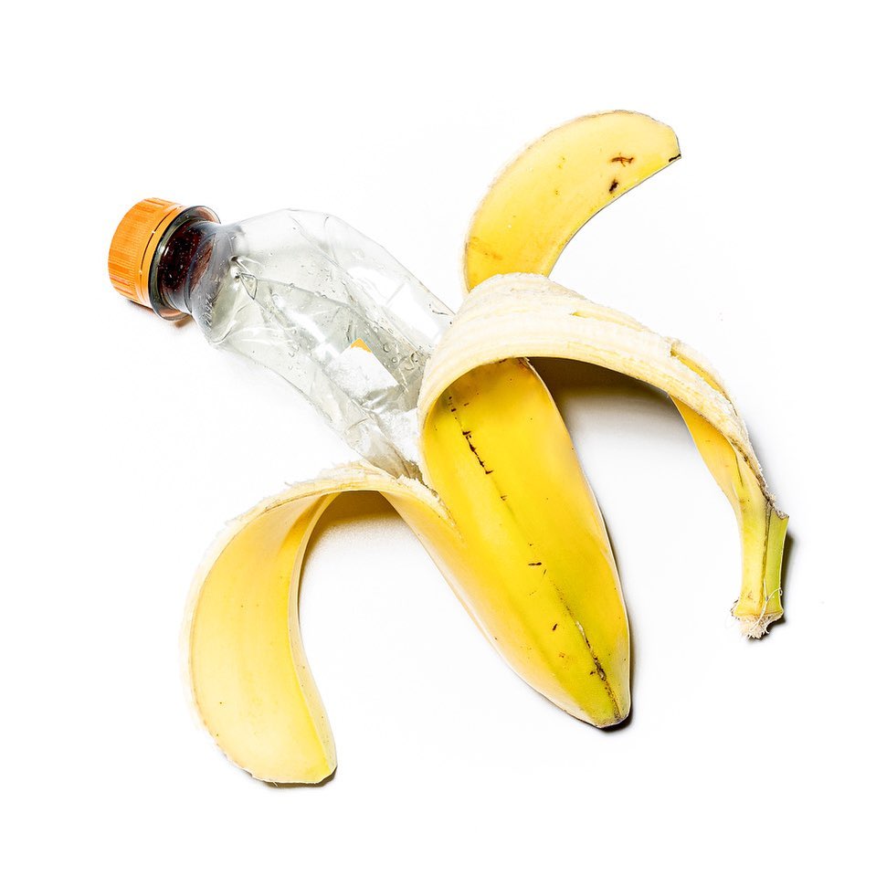 Une banane laisse apparaître une bouteille en plastique