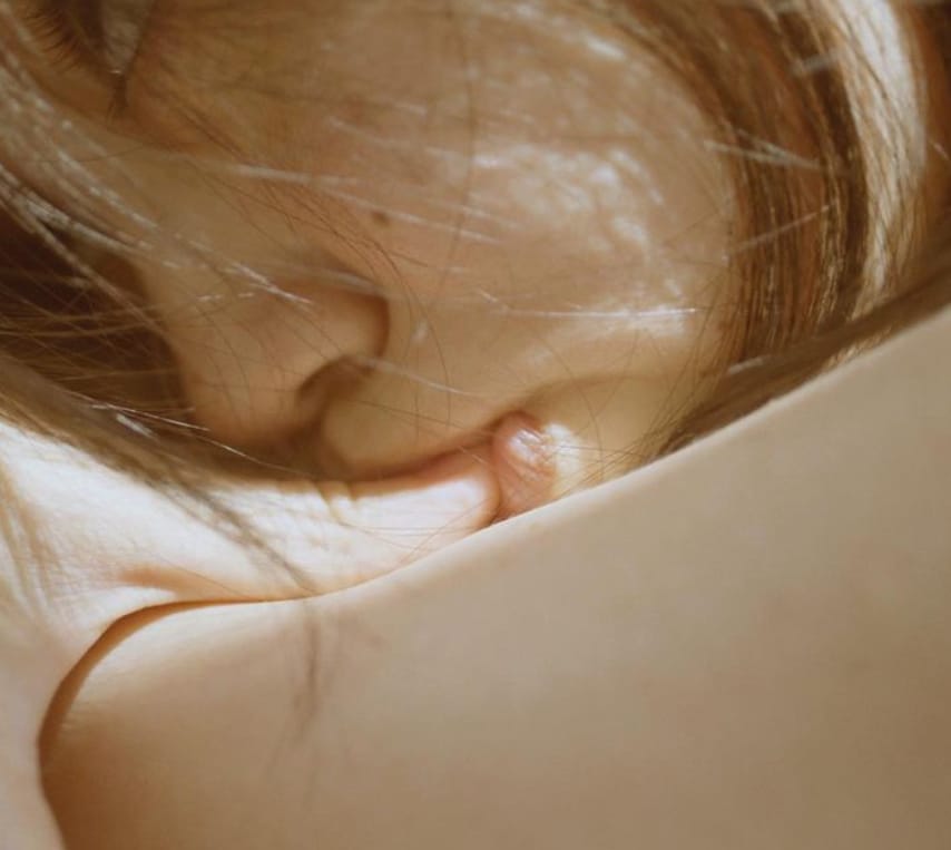 Photographie d'une femme qui s'enlace et qui s'embrasse le pouce par Li Hui